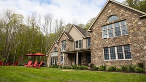 A stone house with a porch and red chairs. - Grand Slam - Lake House Cooperstown Dreams Park (Cooperstown)