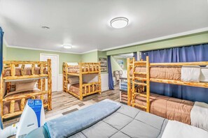 A room with bunk beds, a sofa, and a table with a blue towel.