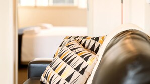 Un salón con sofá y un cojín decorativo estampado.