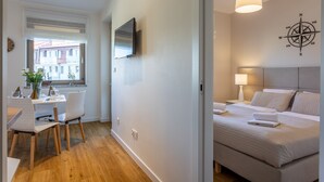 A modern hotel room with a bed, bedside table, lamp, and a TV mounted on the wall. - Vacation apartment by the sea, vacation on the island of Usedom, Apartment VELA ROSA (Swinoujscie)
