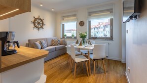 A modern kitchen with a wooden countertop, a built-in coffee maker, and a dining area with a table set for four. - Vacation apartment by the sea, vacation on the island of Usedom, Apartment VELA ROSA (Swinoujscie)