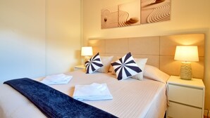 Ein Hotelzimmer mit einem großen Bett, zwei Nachttischlampen und einem Kunstwerk über dem Bett.