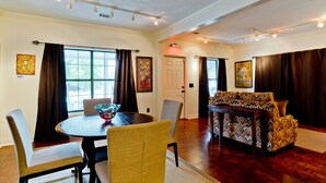 A dining area with a round table, chairs, and a patterned sofa. - 2BR/2BA Walk to downtown! Near the Beach! Perfect location! The Gallery (Ocean Springs)