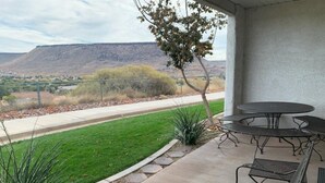 A patio with outdoor seating, a view of a mountain, and a landscaped garden. - 3 bedrooms. 4 TV's. Great view, Nice Reviews. (St. George)