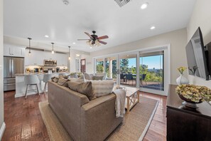 A spacious living area with a sofa, a dining table, and a kitchen in the background. - Bask in San Diego Glory: Bay Views, Blissful Breezes, & Sunsets Bathed in Warmth (San Diego)