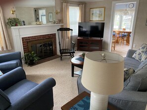 A living room with a fireplace, a television, a sofa, and a lamp.