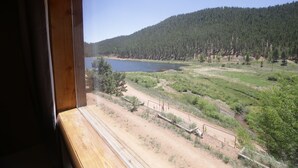 A view from a window overlooking a lake, surrounded by forested hills. - Fawn Haven on the Lake (Bailey)