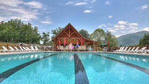 A swimming pool with a wooden pavilion in the center, surrounded by lounge chairs. - Gorgeous, Secluded, SuperFast WiFi, NFL Sunday, Arcade, Gated, Fishing & 2 Pools (Sevierville)
