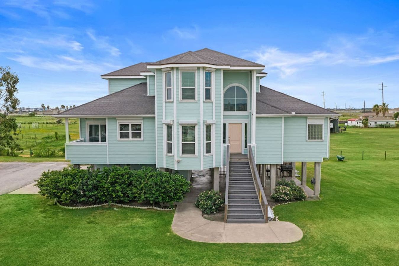 A two-story house with a front porch, a staircase, and a well-maintained lawn.