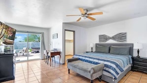A bedroom with a bed, a desk, a chair, a ceiling fan, and a view through a glass door. - Luxury 5BR | Private Pickleball, Pool, Spa (Scottsdale)