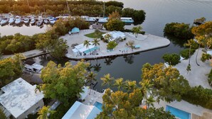 Vista aérea de uma marina com barcos, piscina e um cais.