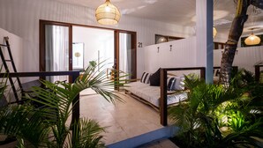 A modern bedroom with a bed, a wooden bench, and a staircase.