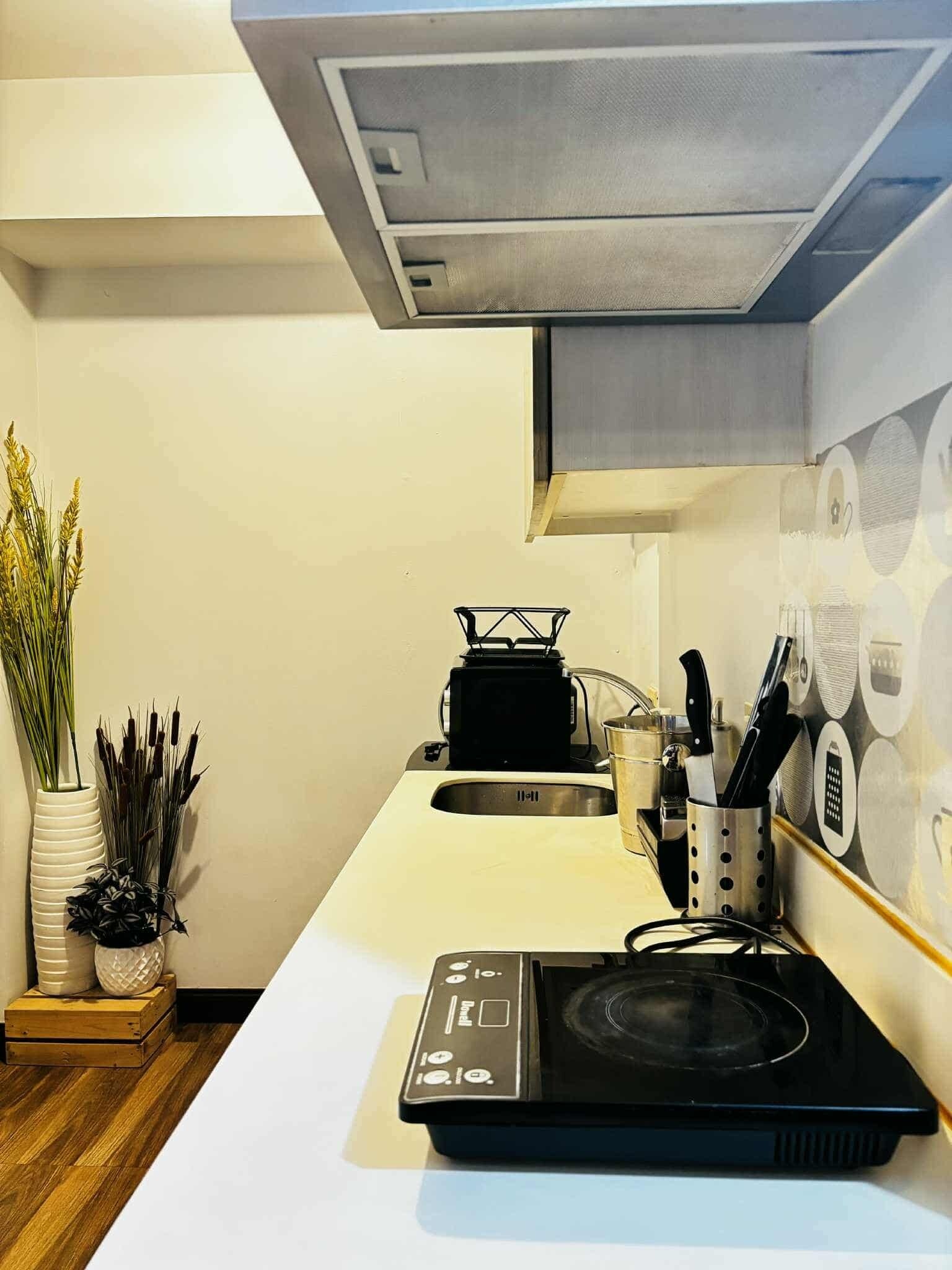 Una cocina con estufa integrada, lavamanos y salpicadero con diseños circulares.