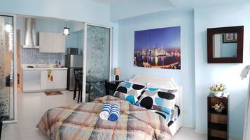 Un dormitorio con una cama, una mesita de noche y vistas a un paisaje urbano.