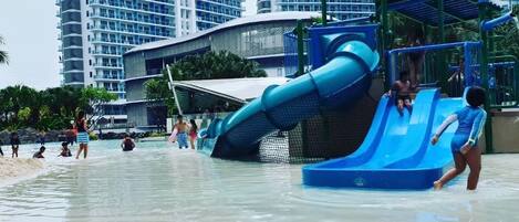 A water park with a large blue slide and a red bucket lift.