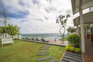 A coastal view with a grassy area, a wooden pathway, and a bench. - Marino Beach Colombo (Colombo)