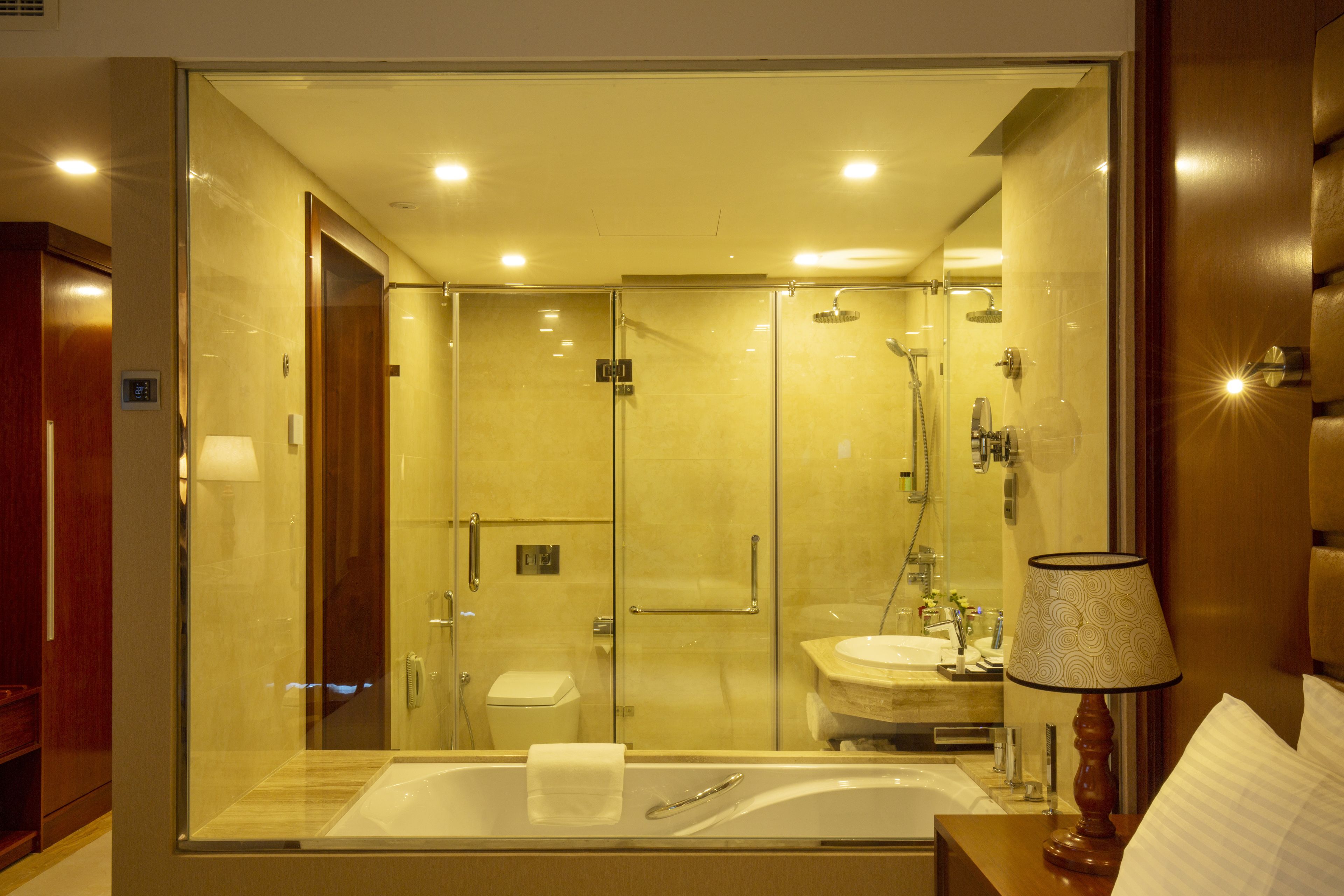 Un baño moderno con ducha envuelta en vidrio, una bañera independiente y un tocador con lavabo.