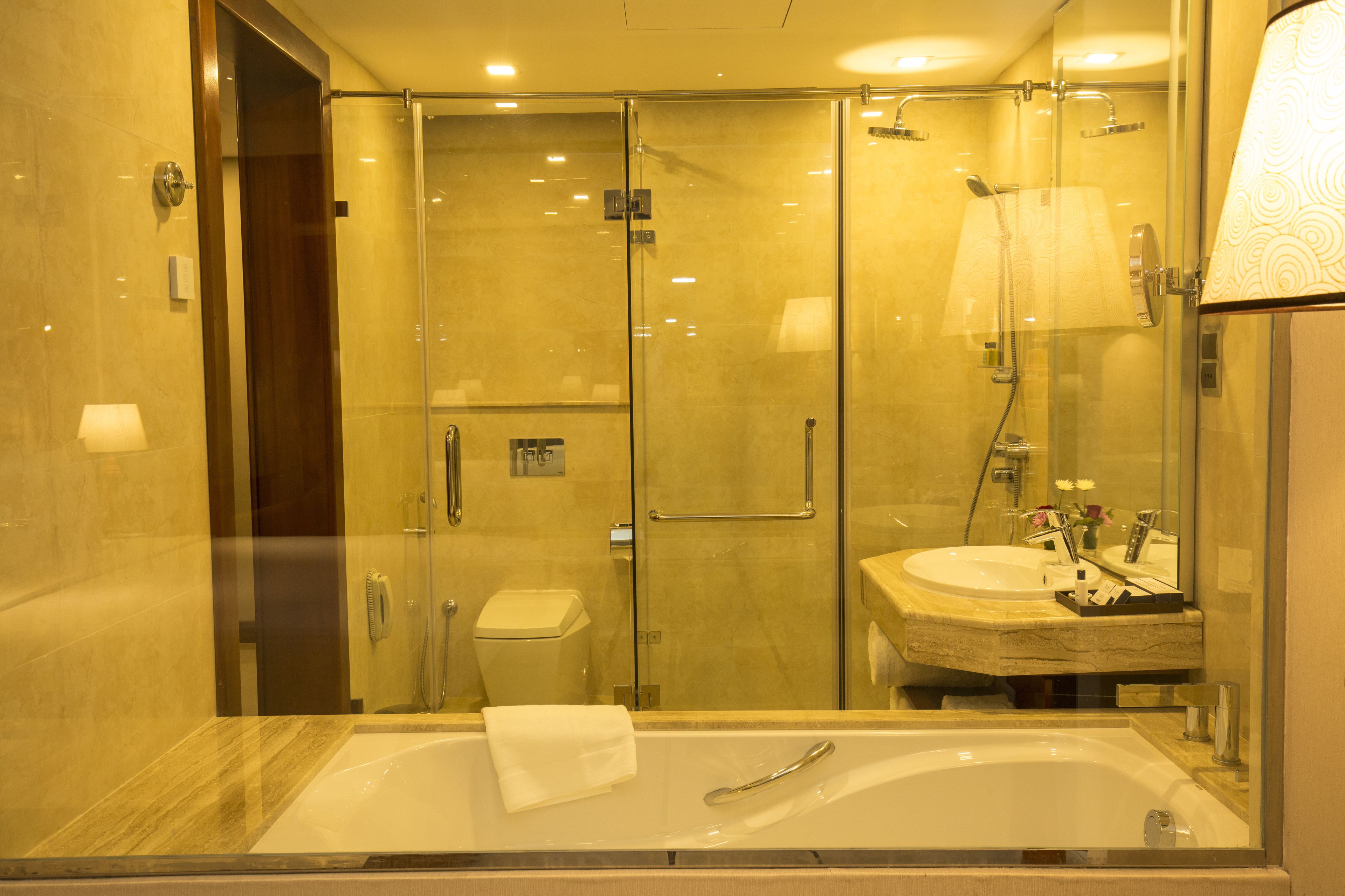A modern bathroom with a glass-enclosed shower, a standalone bathtub, and a vanity with a mirror.