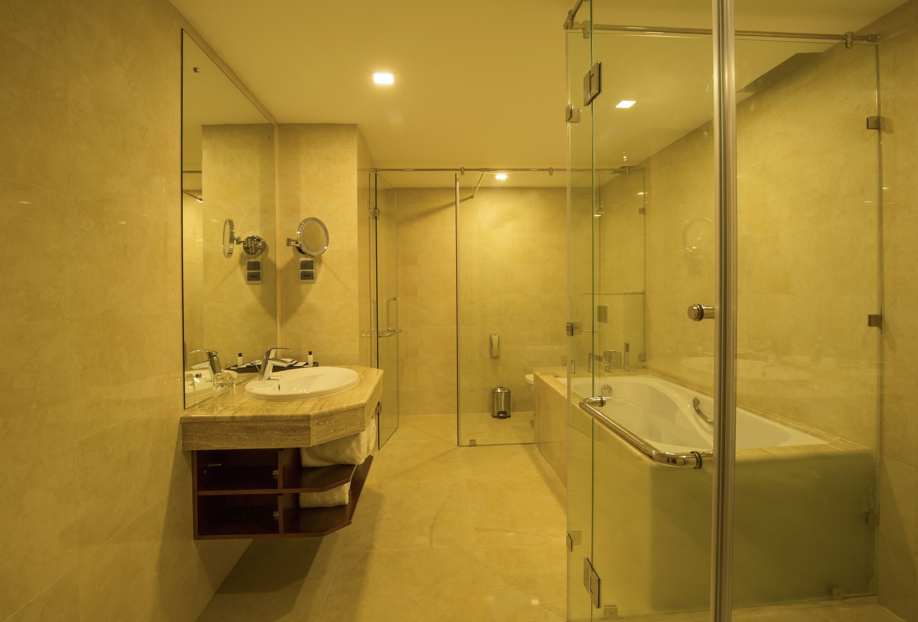 A modern bathroom with a glass-enclosed shower, a double sink vanity, and a standalone bathtub.