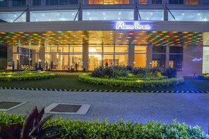 The exterior of Marino Beach hotel with a glass facade, outdoor seating area, and well-maintained landscaping. - Marino Beach Colombo (Colombo)