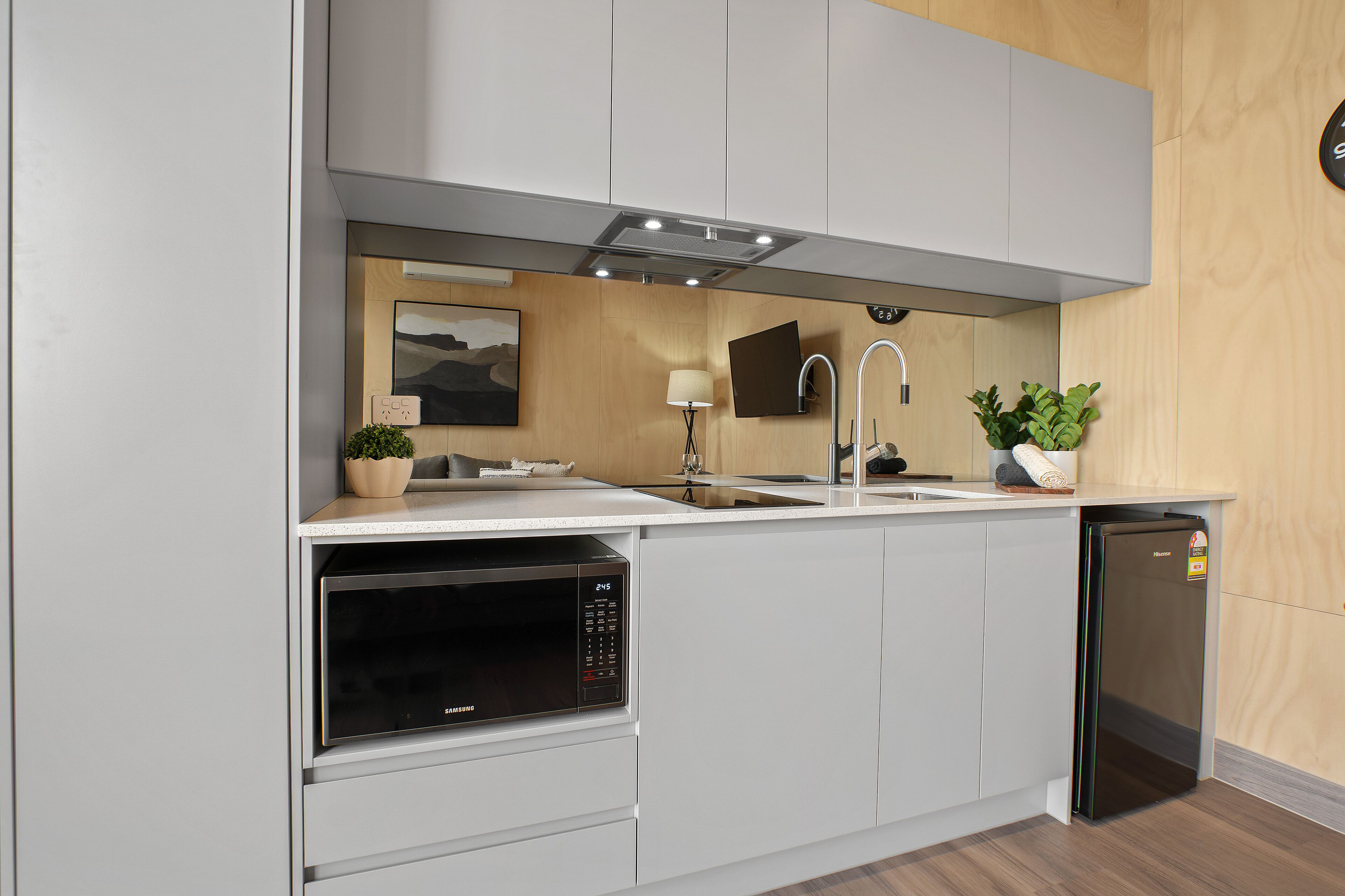 Una cocina moderna con electrodomésticos integrados, un lavabo y un microondas.