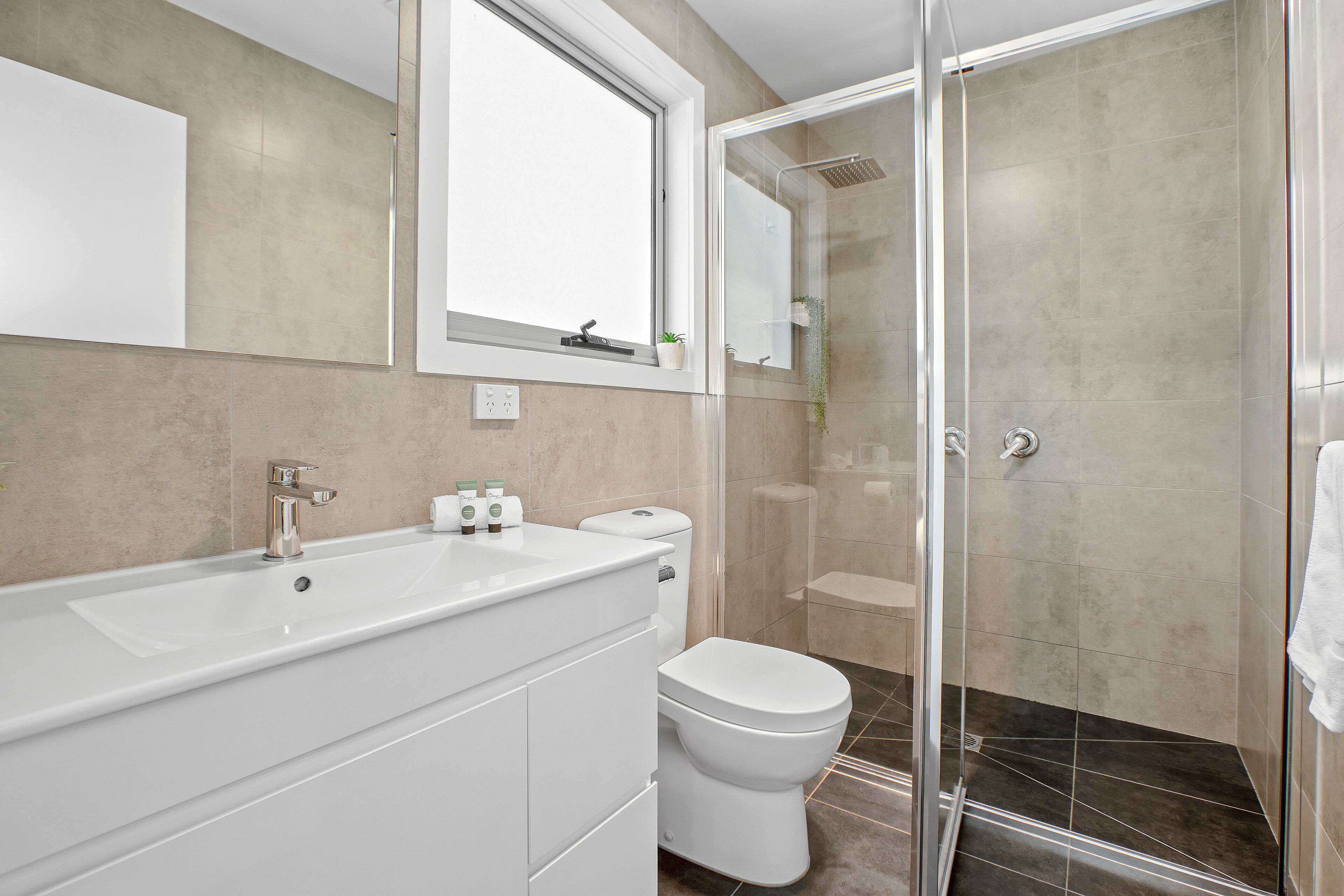 Une salle de bain moderne dotée d’une grande baignoire, de toilettes et d’une cabine de douche en verre.