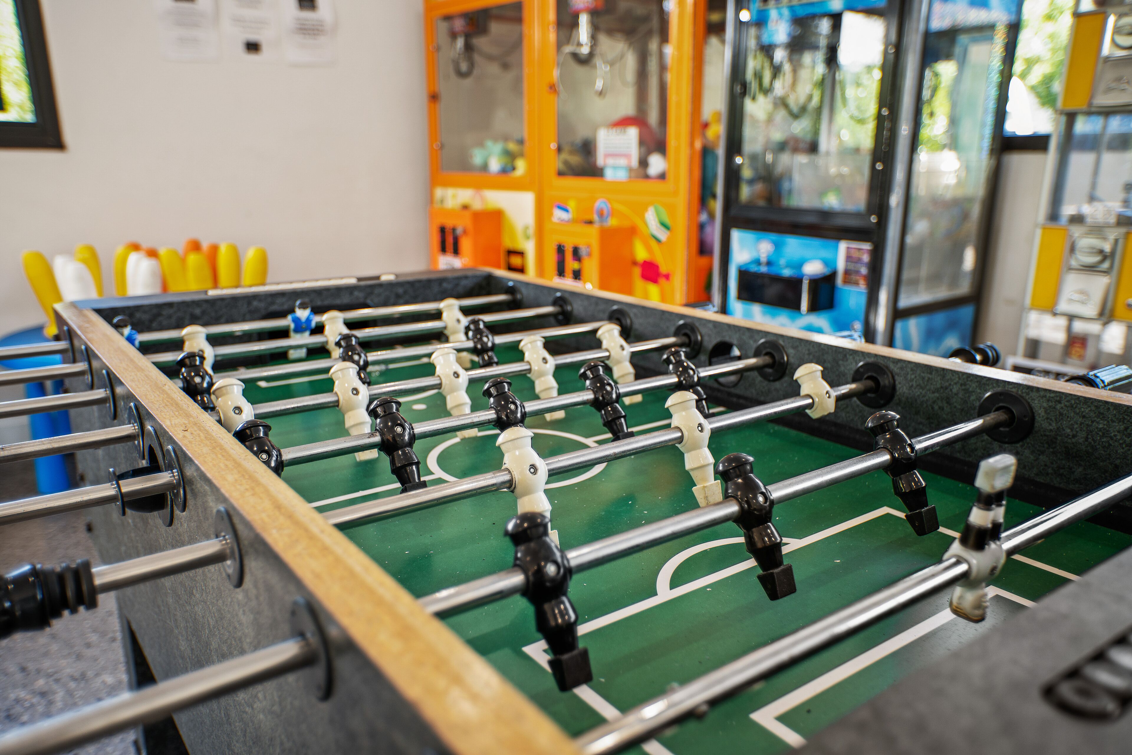 A foosball table with a green playing surface and metal rods.