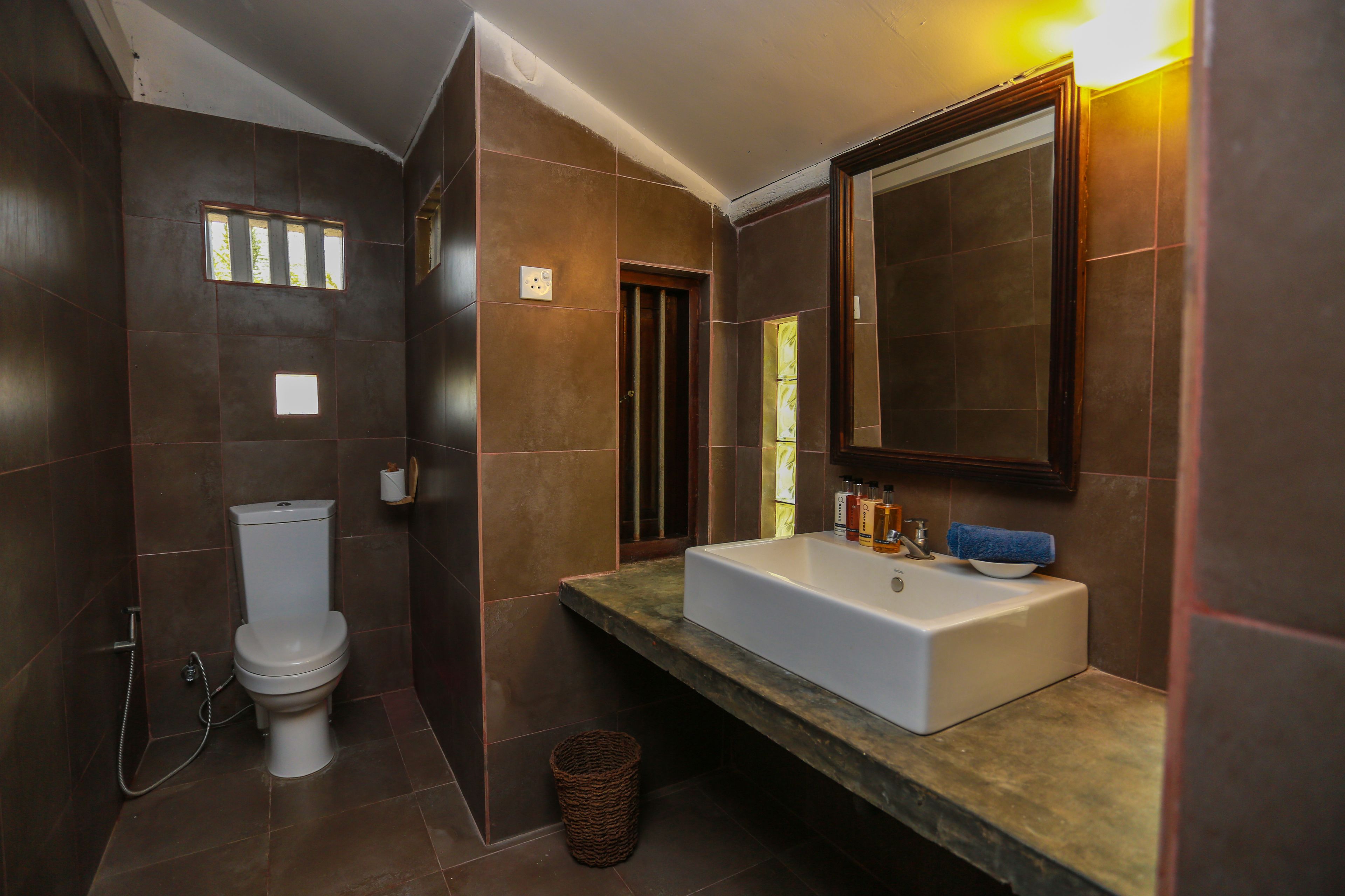 A modern bathroom with a toilet, sink, and mirror.