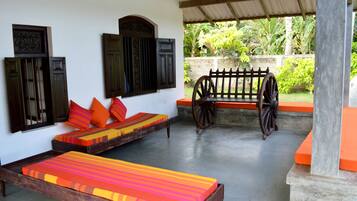 A room with a bed, a bench, and a wheelbarrow.