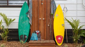 Une porte en bois, avec des planches de surf et du matériel de plongée devant.