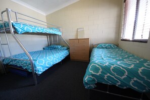 A dormitory room with bunk beds, a dresser, and a window with blinds. - Air conditioned *ground floor own carport * Sheets/Towels not included (Hat Head)