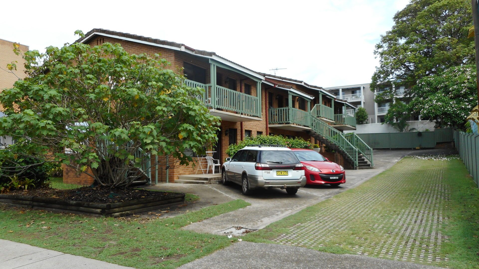 A two-story residential building with a balcony and a staircase leading to the upper floor.