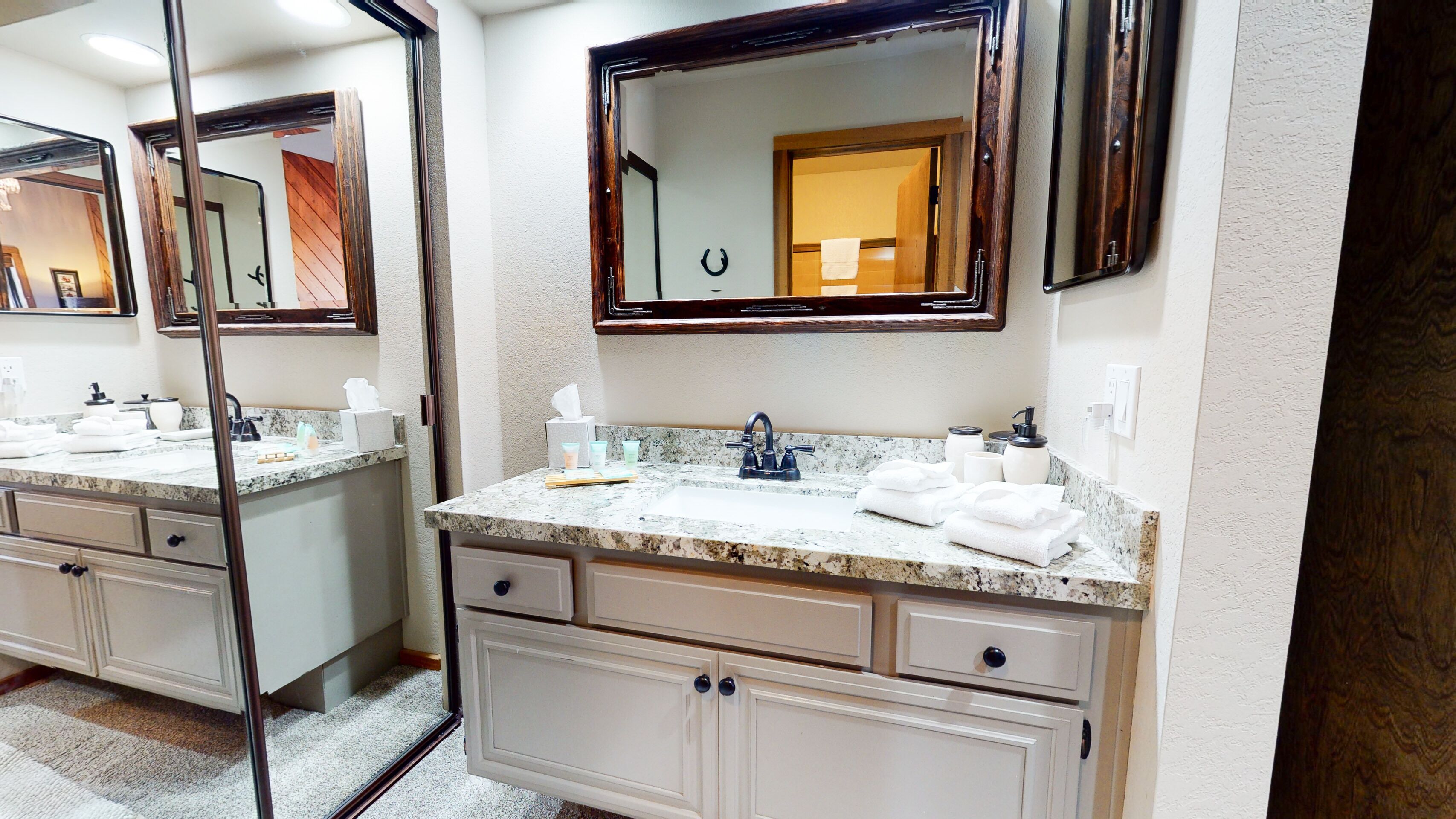 A bathroom with two sinks, marble countertops, and a large mirror.