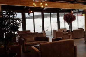 A cozy interior with sofas and a large window offering a snowy outdoor view. - Sarikamis Kayi Snow Otel (Sarikamis)