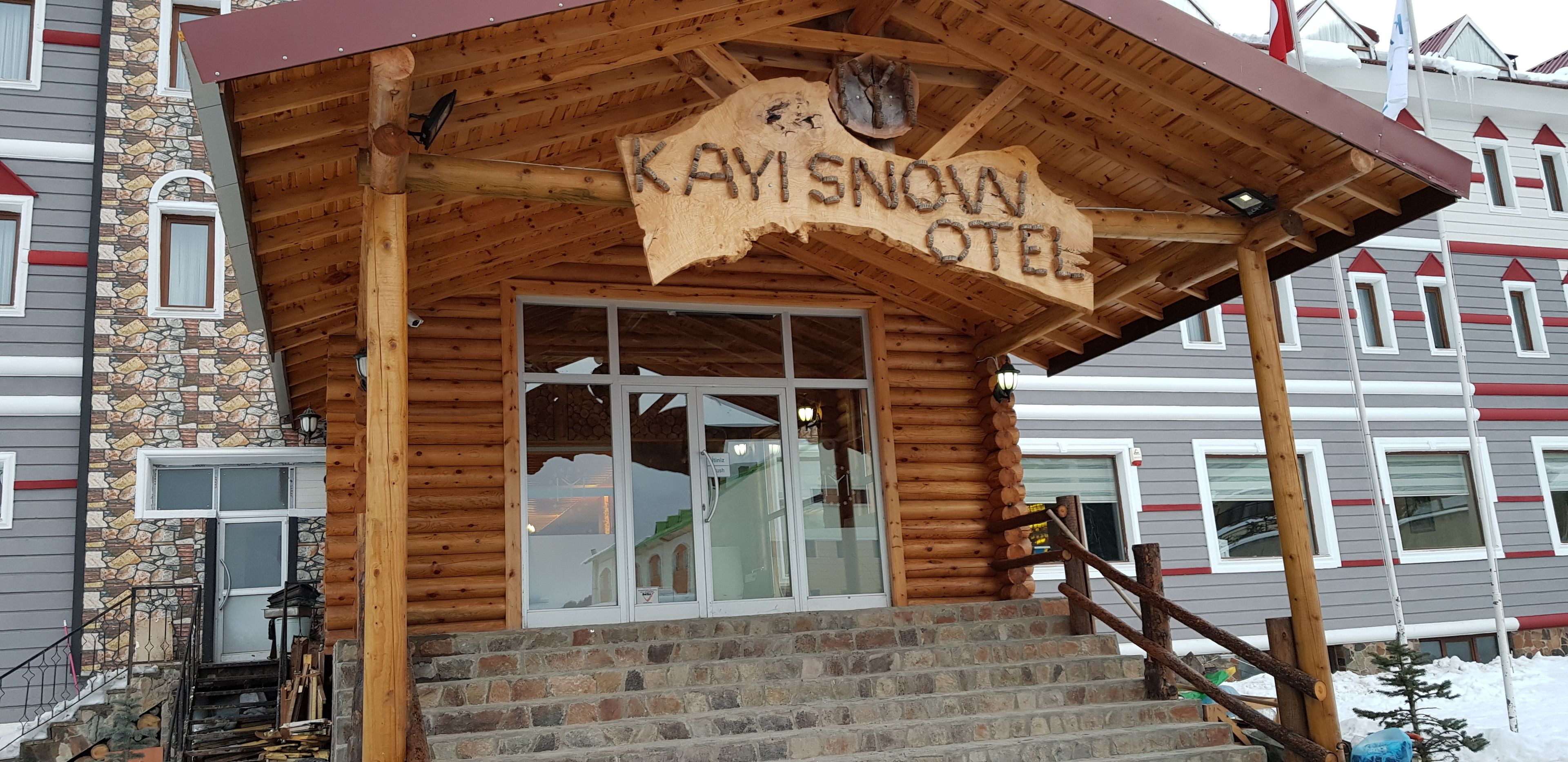 Un edificio de madera con un cartel que dice "KAYISNOW OTEI".