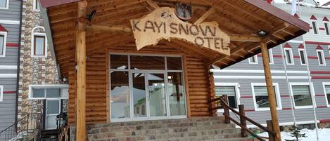Un edificio de madera con un cartel que dice "KAYISNOW OTEI".