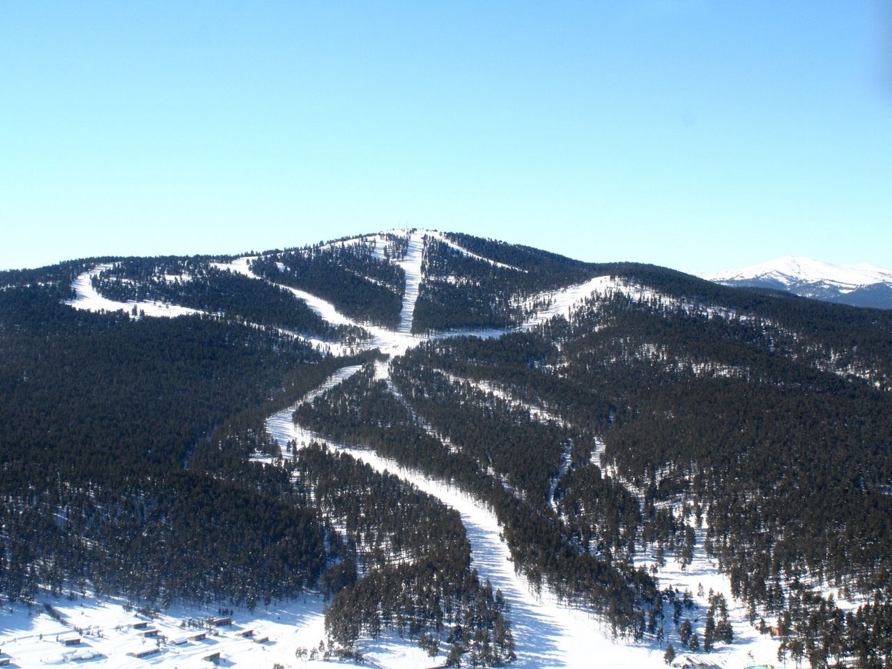 A snow-covered mountain with a ski trail.