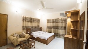 Une chambre à coucher comprenant un lit, un canapé, une table basse, une armoire et des rideaux.