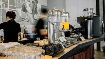 A coffee bar with espresso machines, a coffee press, and a variety of coffee cups and glasses.