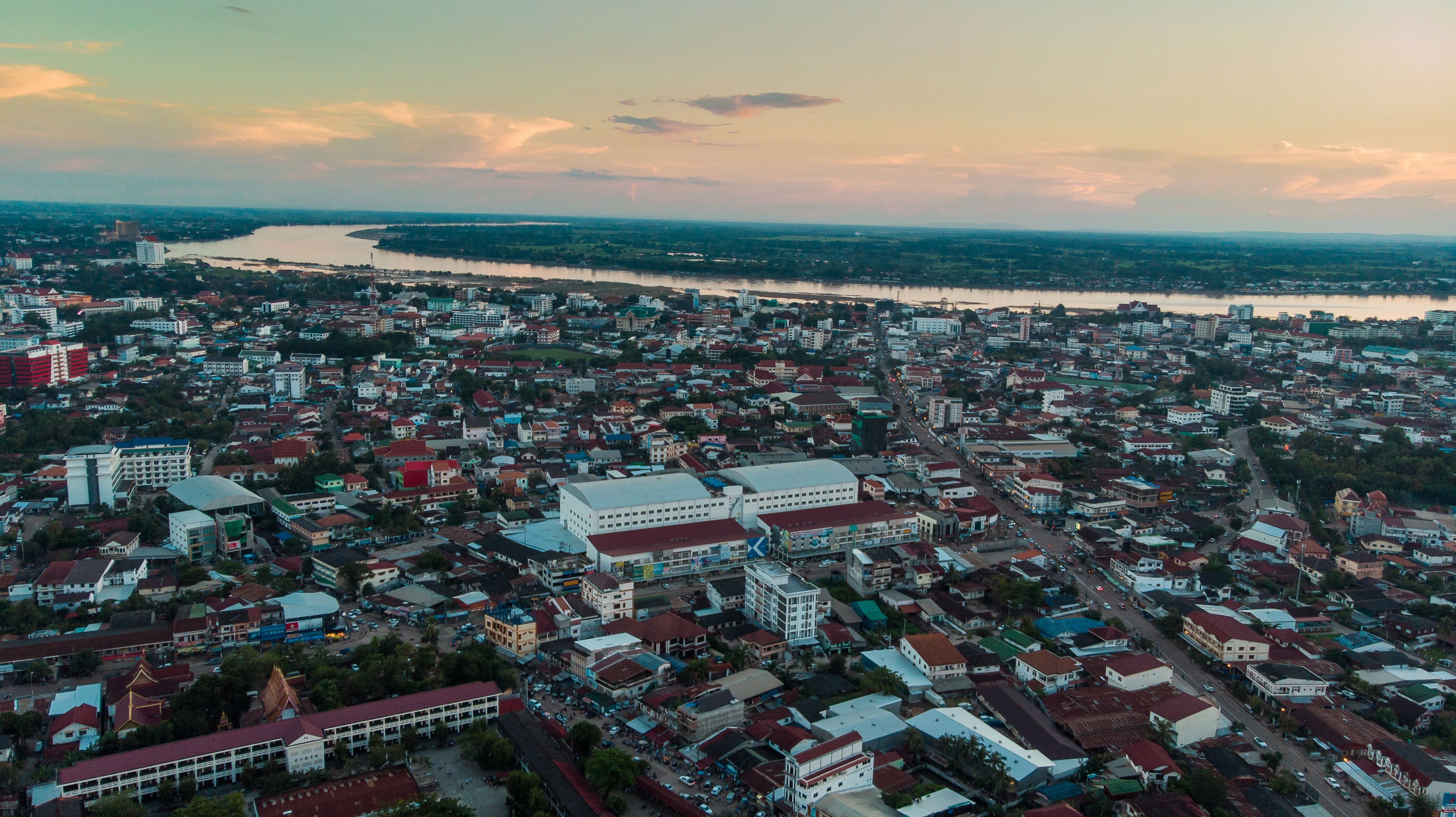 An aerial view of a city with dense urban development, a river, and a mix of residential and commercial buildings.
