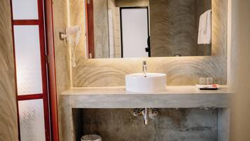 A bathroom with a marble sink, a hairdryer, and a towel hanging on the wall.