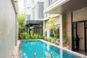Una piscina al aire libre, sillones reclinables de piscina
