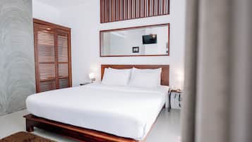 Un dormitorio moderno con una cama grande, cabecera de madera, televisor montado en la pared y un espejo amplio.