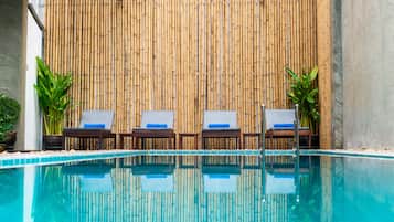 Una piscina al aire libre, tumbonas