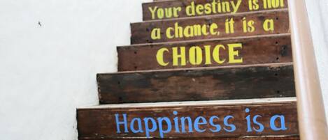 Una escalera de madera con citas motivacionales pintadas en los peldaños.