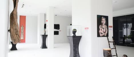 Una galería de arte con varias esculturas y pinturas exhibidas.