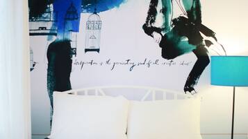 Een slaapkamer met een bed, een lamp en een groot abstract schilderij aan de muur.