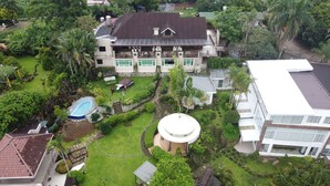 Een ruim huis met een zwembad, een fontein en een verzorgde tuin.