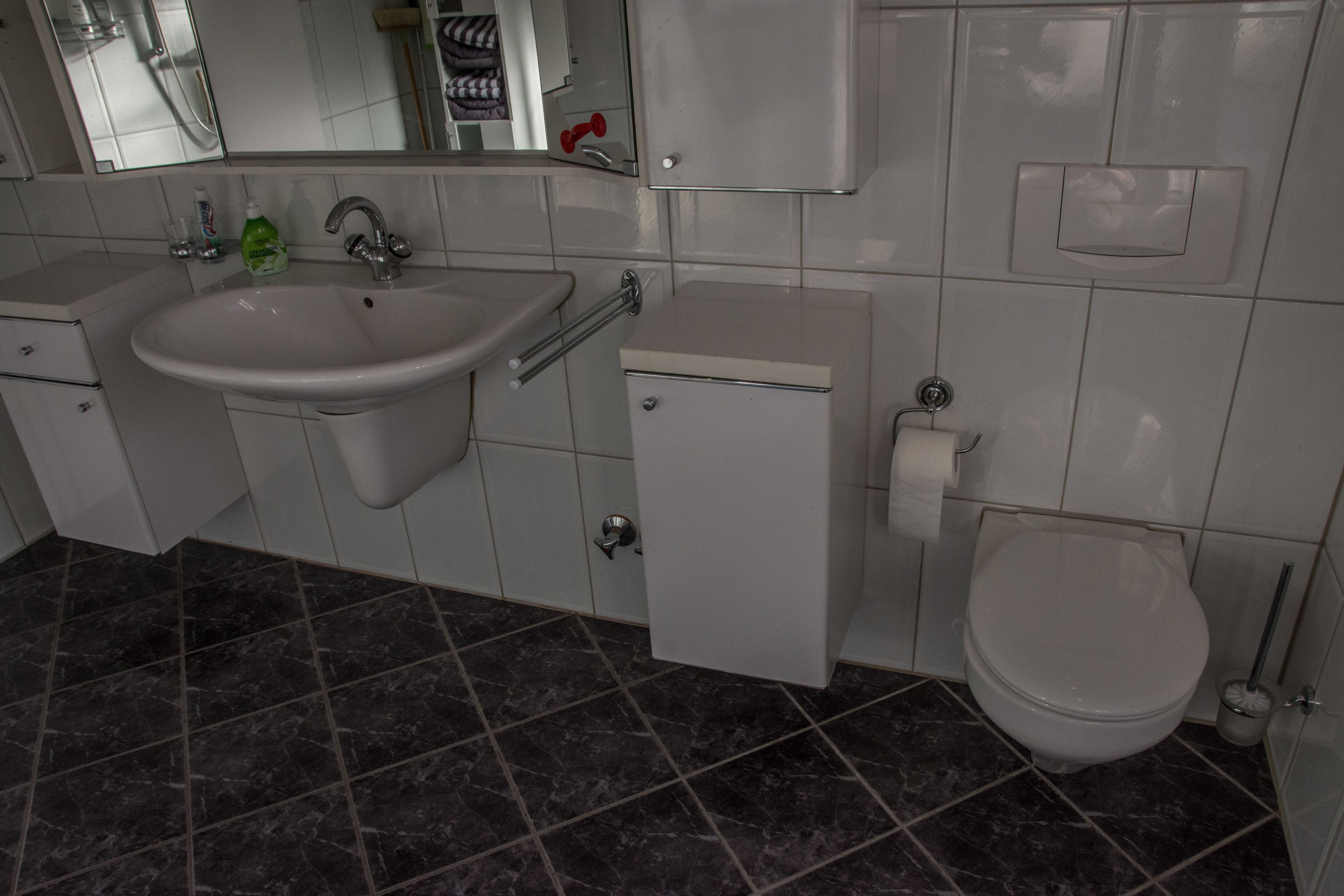 Een badkamer met een wastafel, toilet en bidet.