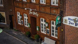 Un edificio de ladrillo con un letrero que dice 'Biergarten Zur Post'.